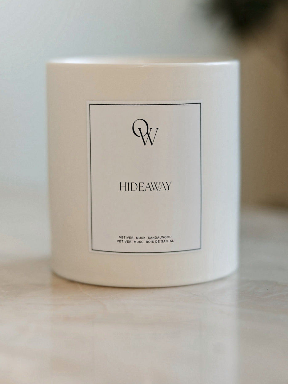 One Wednesday Hideaway soy candle in a white vessel.