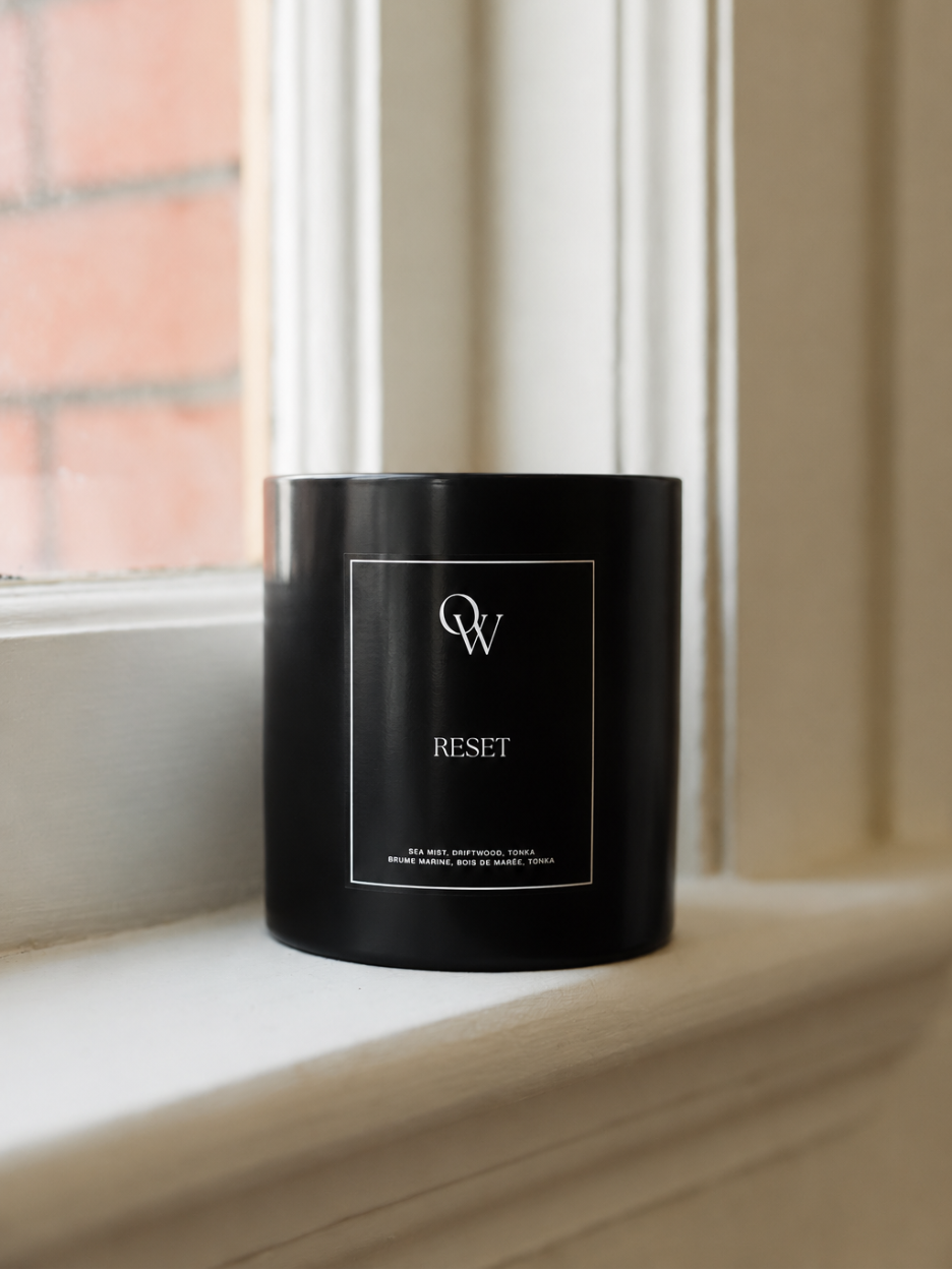 One Wednesday Reset soy candle in a black vessel.